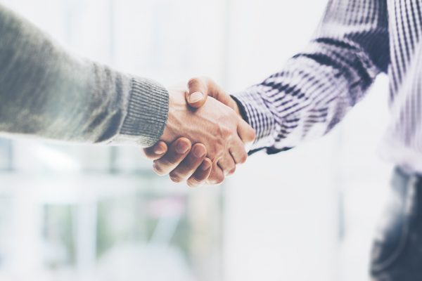 Business partnership meeting concept. Image businessmans handshake. Successful businessmen handshaking after good deal. Horizontal, blurred background